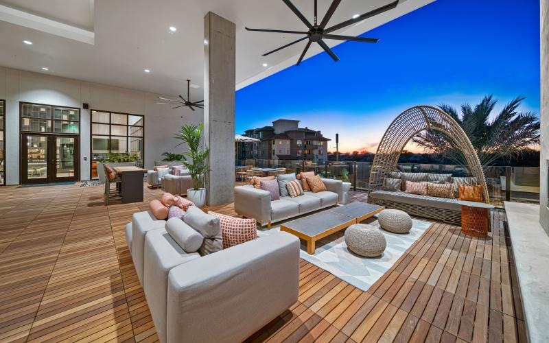 an outdoor lounge area with couches and a table